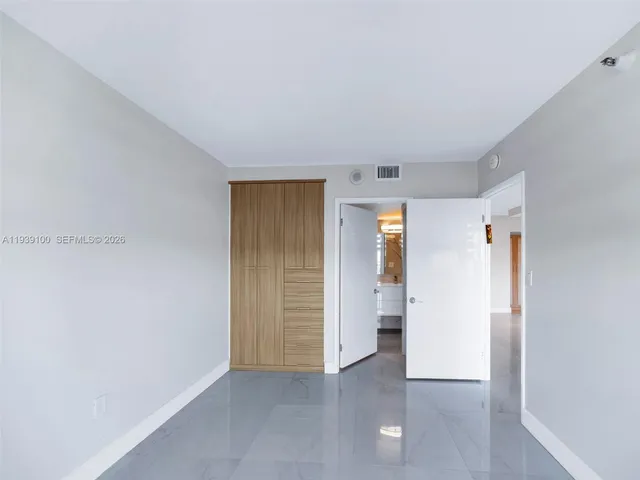an empty room with closet and wooden door