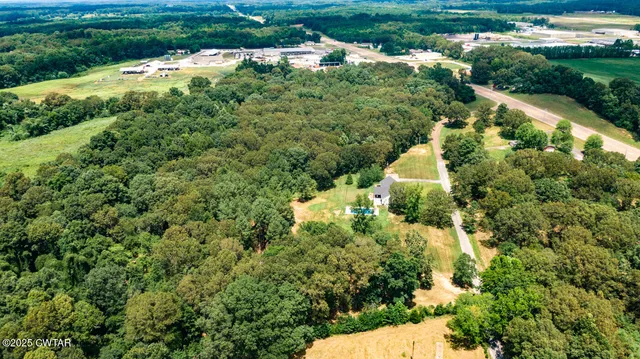 an aerial view of a house with a yard and lake view