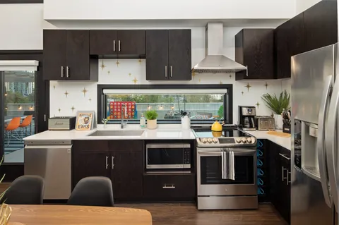 a kitchen with stainless steel appliances a stove refrigerator and cabinets