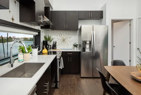 a kitchen with stainless steel appliances granite countertop a sink a refrigerator and a stove