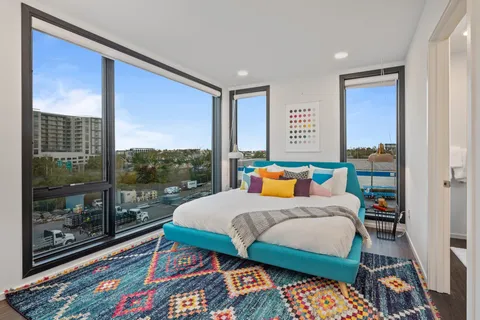 a bedroom with a bed and a dresser next to a window