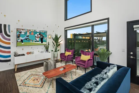 a living room with furniture and a floor to ceiling window