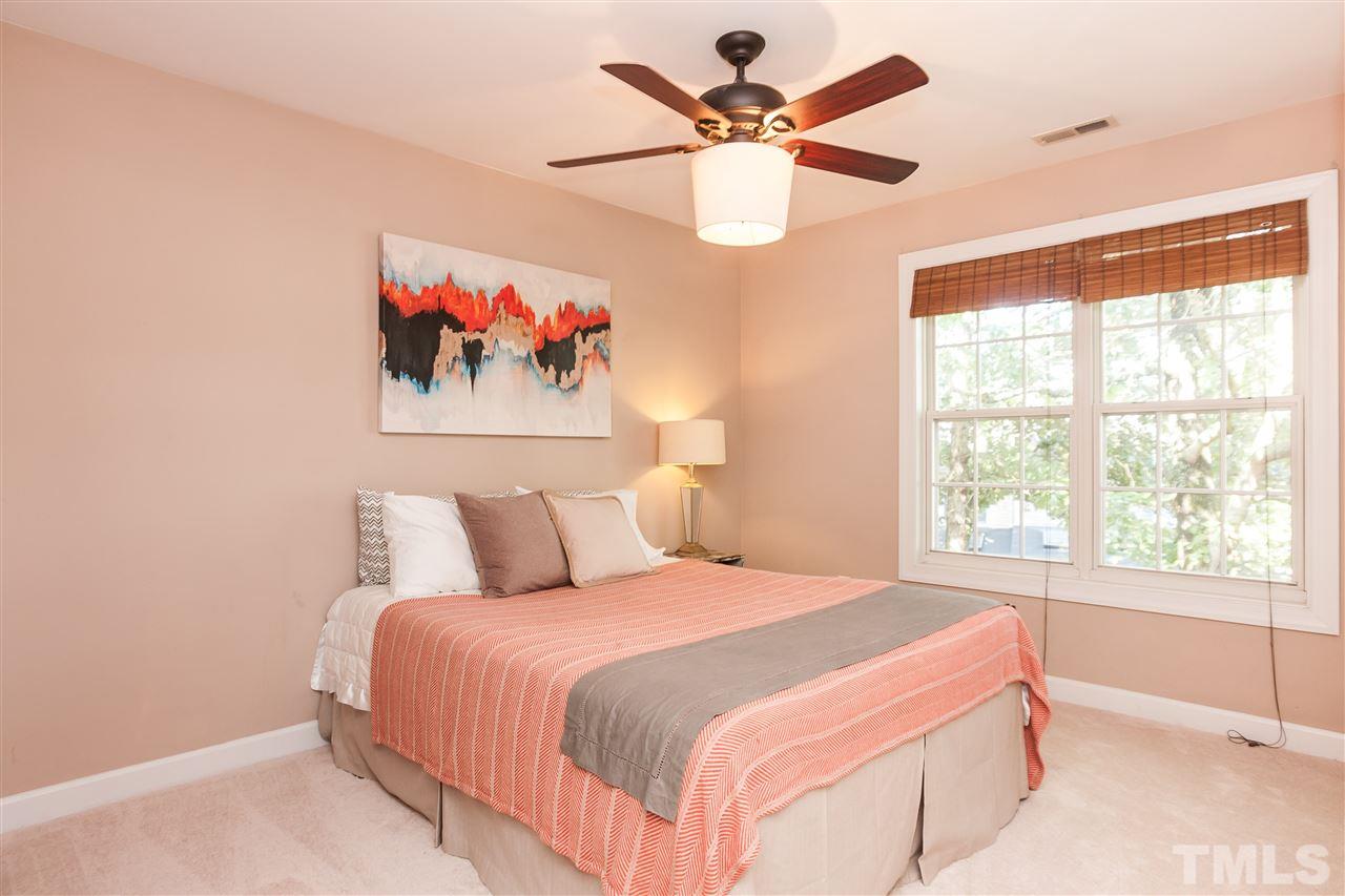 2608 Sterling Park Drive Raleigh, NC 27603 - Photo 14 of 21 a bedroom with a large bed and a chandelier
