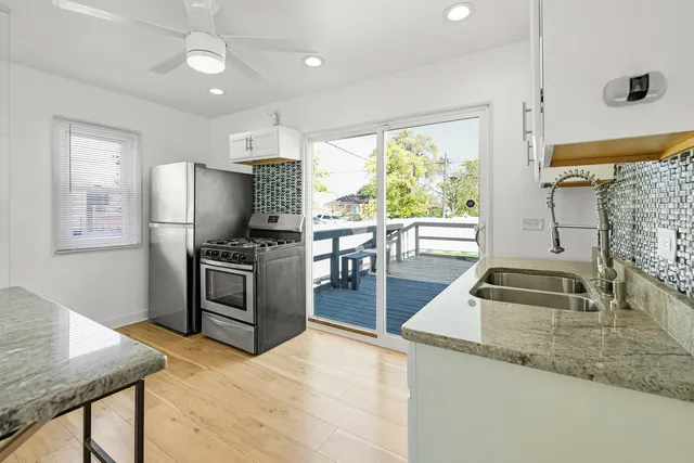 a kitchen with granite countertop a refrigerator stove and sink