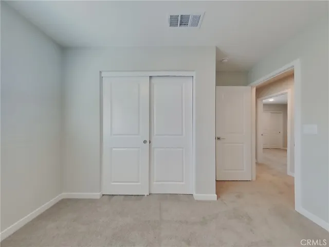 a view of an empty room and closet area