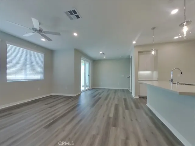a view of an empty room and a kitchen