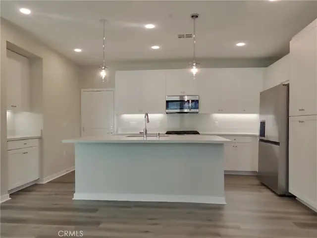 a kitchen with stainless steel appliances a refrigerator sink and microwave