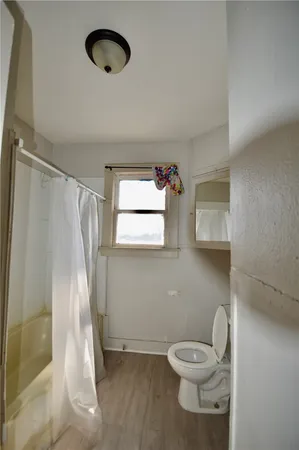 a bathroom with a toilet and a shower