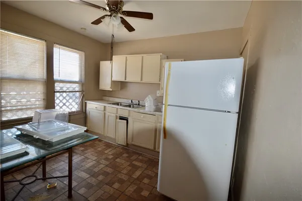 a kitchen with a refrigerator a stove cabinets and a dining table