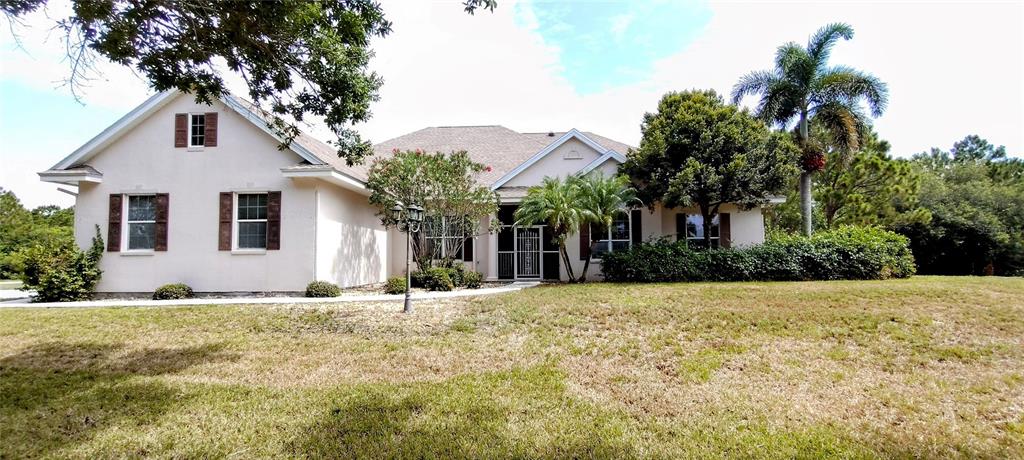 a front view of house with yard and trees around