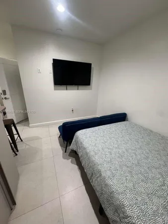 a bedroom with a bed and a flat screen tv