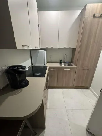 a kitchen with a sink a microwave and cabinets