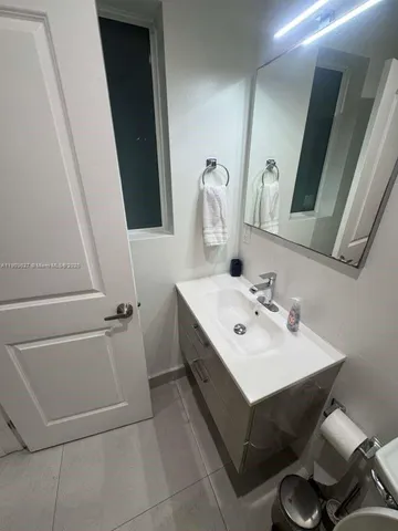 a bathroom with a sink and mirror with toilet