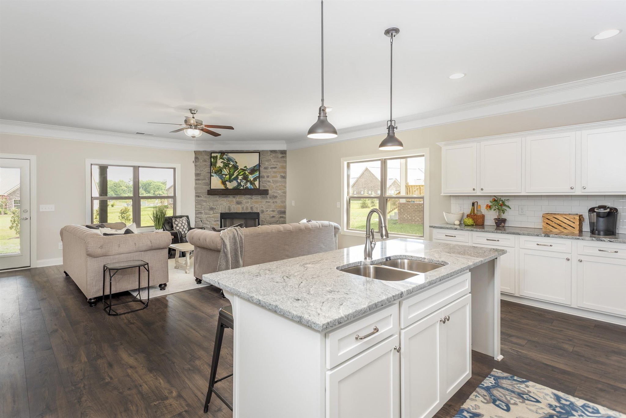 3211 Rift Lane Murfreesboro, TN 37130 - Photo 2 of 17 a kitchen with kitchen island granite countertop a stove a sink a dining table and chairs with wooden floor