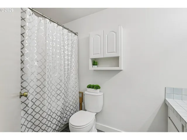 a bathroom with a toilet and a shower curtain
