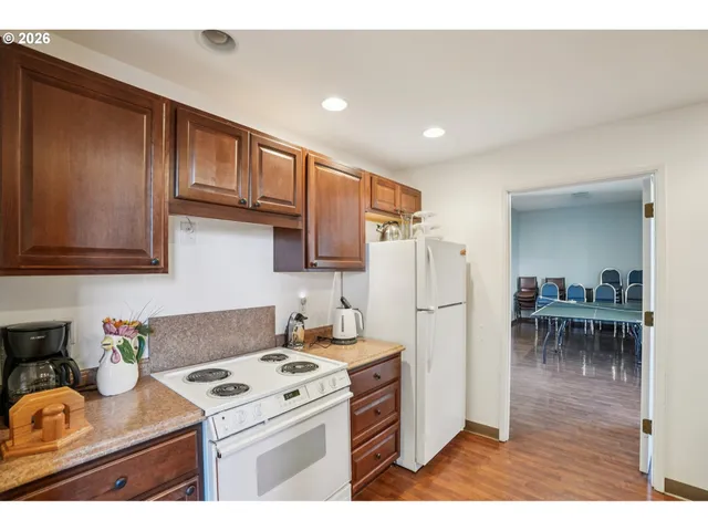 a kitchen with a stove a refrigerator and a dining table