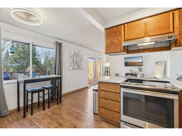 a kitchen with a stove a sink and wooden cabinets