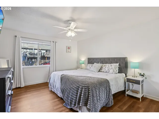 a bedroom with a bed a ceiling fan and a window
