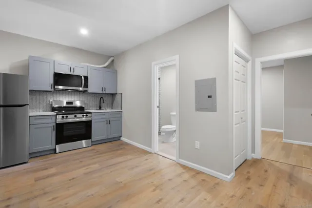 a kitchen with granite countertop a refrigerator and a stove top oven