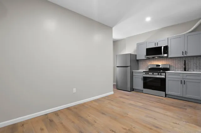 a kitchen with a refrigerator and a stove top oven
