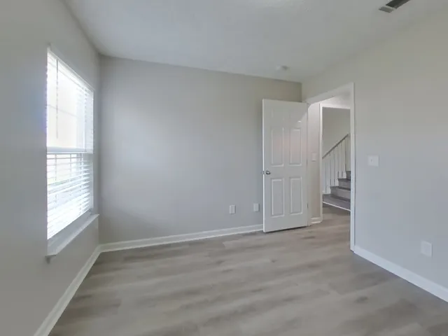 an empty room with windows and closet
