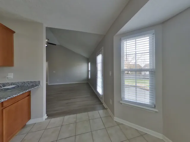 wooden floor in an empty room with a kitchen