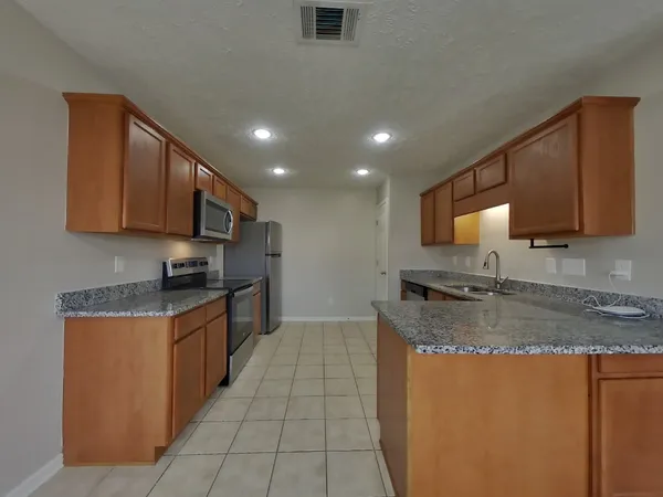 a kitchen with stainless steel appliances granite countertop a sink stove and cabinets