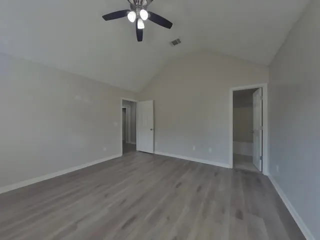 a view of an empty room with wooden floor
