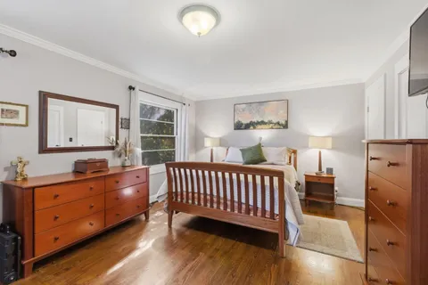 a bedroom with bed and wooden floor