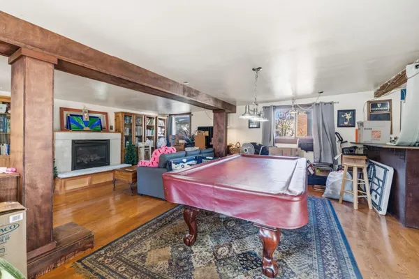 a living room with furniture a pool table and a fireplace