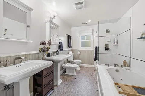 a spacious bathroom with a double vanity sink mirror and toilet