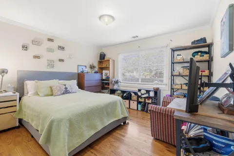 a bedroom with bed and wooden floor