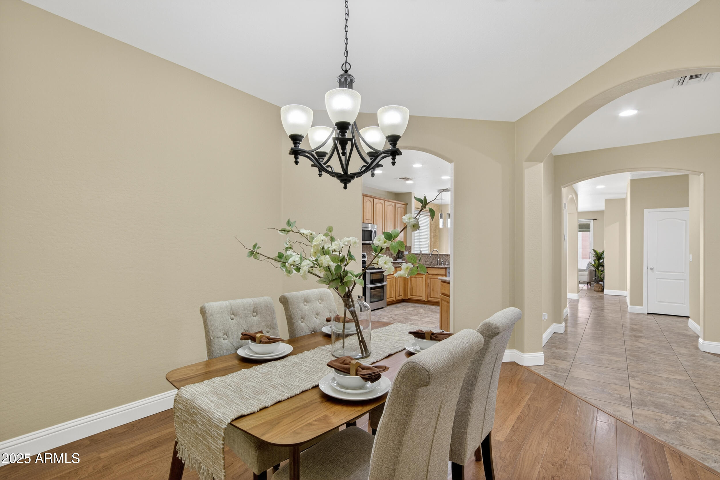 17368 West Red Bird Road Surprise, AZ 85387 - Photo 19 of 82 a view of a dining room with furniture a chandelier and wooden floor