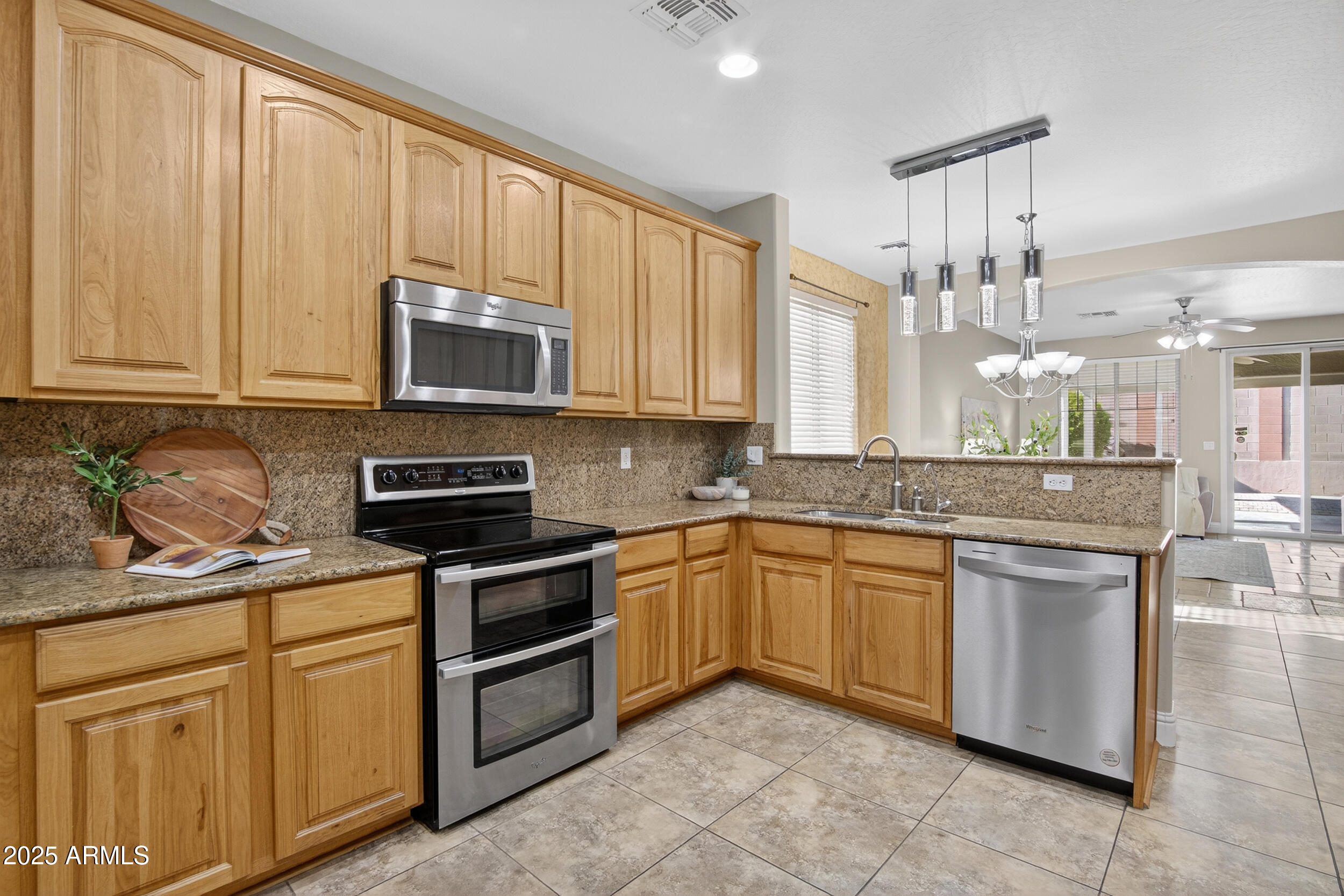 17368 West Red Bird Road Surprise, AZ 85387 - Photo 2 of 82 a kitchen with stainless steel appliances granite countertop a stove sink and microwave
