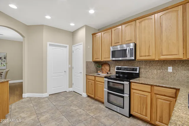 a kitchen with a sink a counter top space stainless steel appliances cabinets and a window