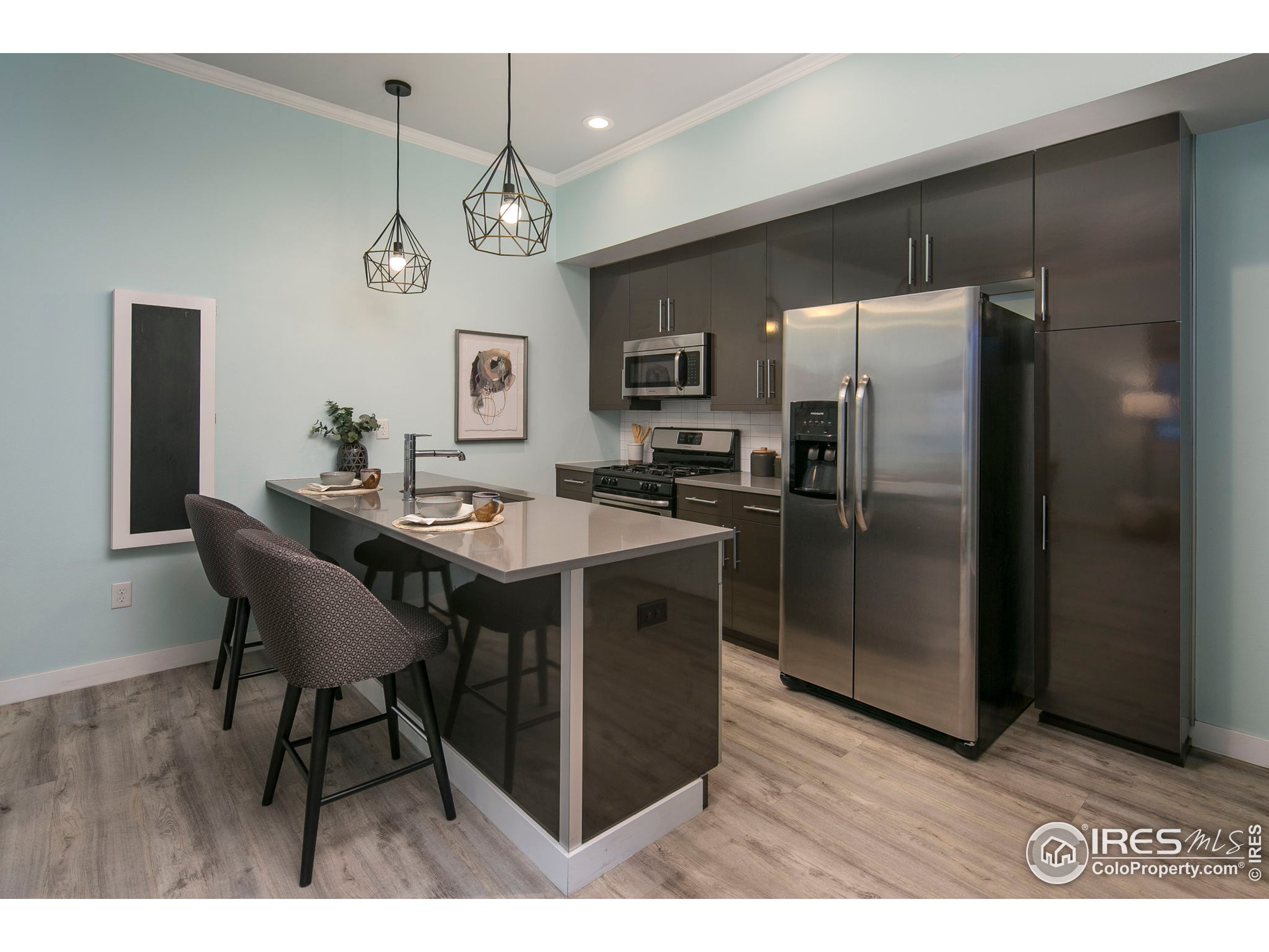 2445 Junction Place, Unit 103 Boulder, CO 80301 - Photo 5 of 29 a kitchen with a refrigerator a sink dishwasher a dining table and chairs with wooden floor