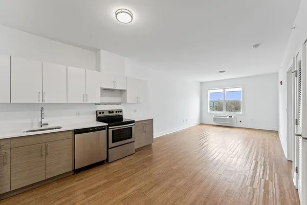 a kitchen with a sink and wooden floor