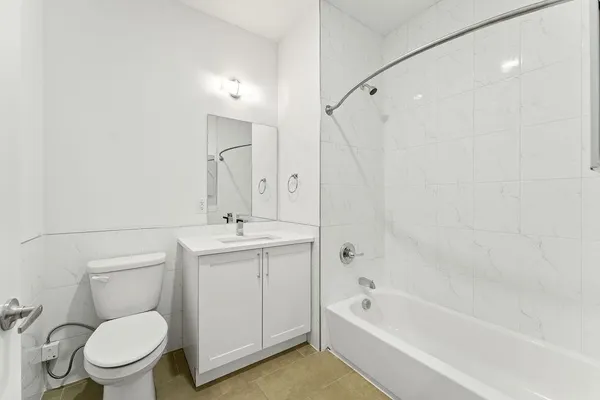 a bathroom with a granite countertop toilet a sink and a bathtub