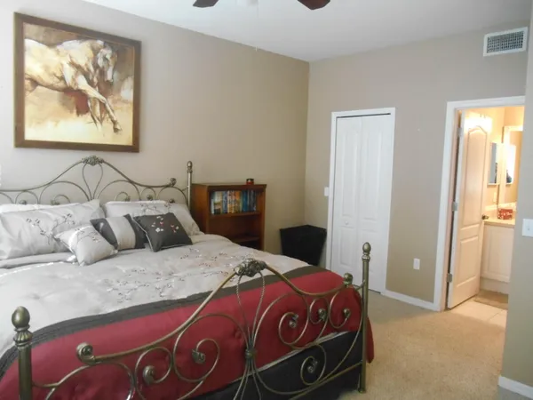 a bedroom with a bed and a painting on the wall