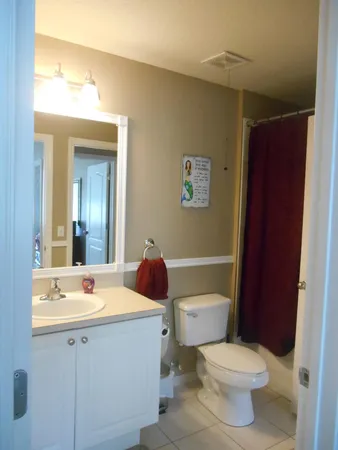 a bathroom with a toilet a sink and mirror