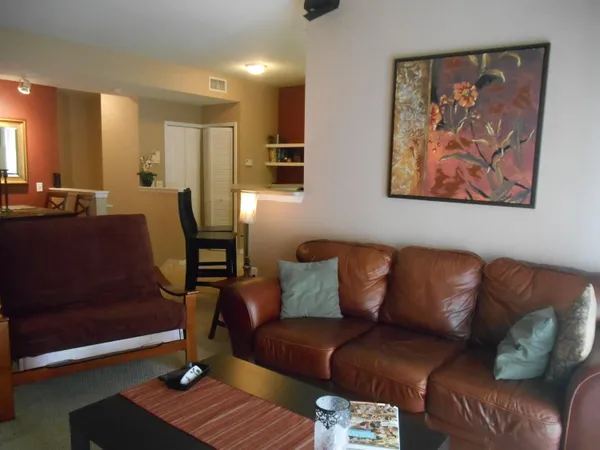 a living room with furniture and a mirror