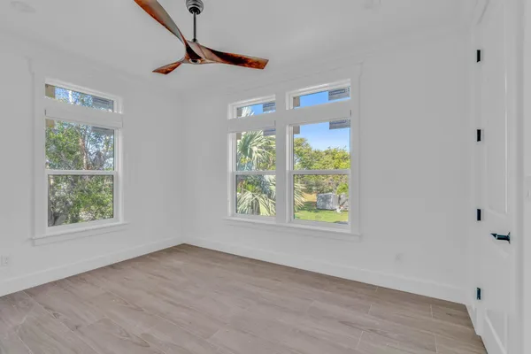 an empty room with a window and a ceiling fan