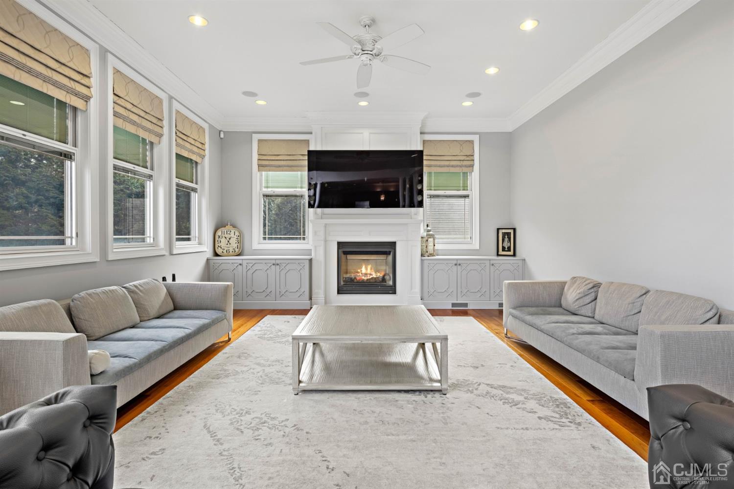 8 Madden Court Edison, NJ 08820 - Photo 28 of 75 a living room with furniture a flat screen tv and a fireplace