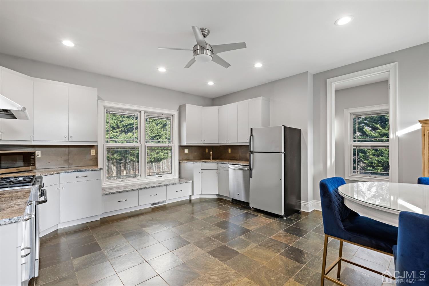8 Madden Court Edison, NJ 08820 - Photo 39 of 75 a kitchen with a refrigerator a stove top oven a sink dishwasher a dining table and chairs with wooden floor
