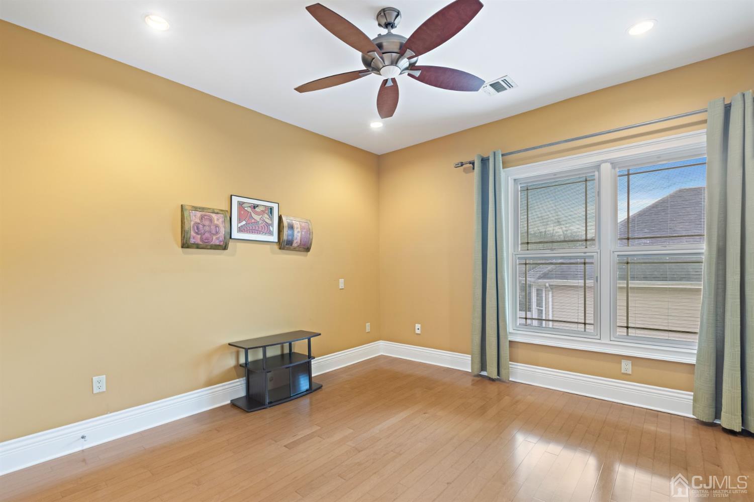 8 Madden Court Edison, NJ 08820 - Photo 54 of 75 a view of a livingroom with a ceiling fan and wooden floor