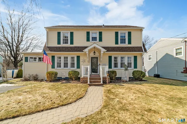 a front view of a house with cars parked