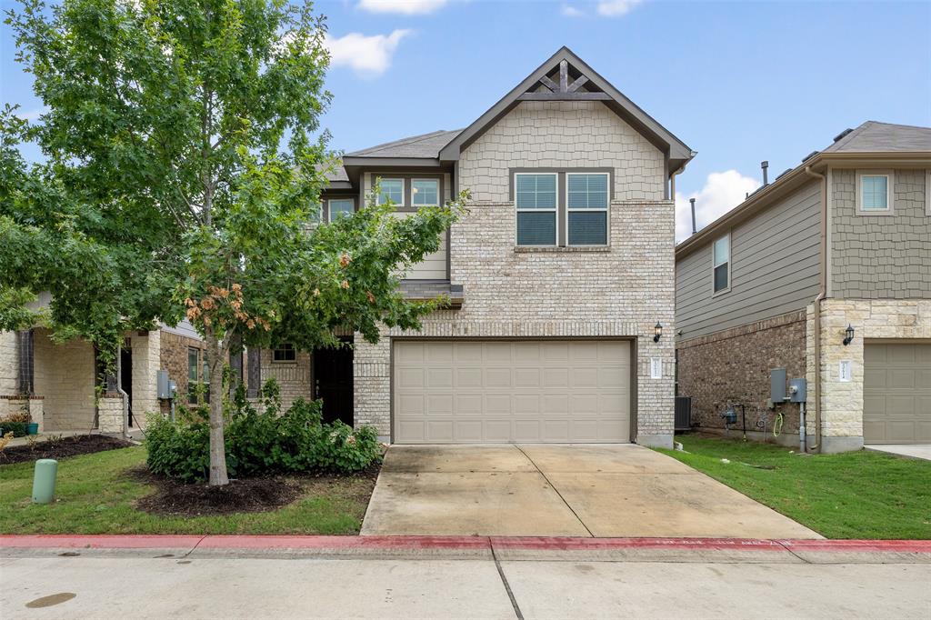 a front view of a house with a yard and a garage