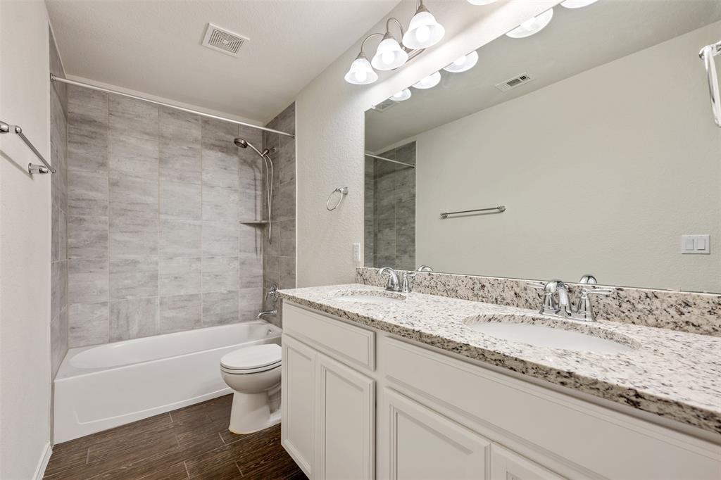 10612 Turnbull Loop, Unit 30 Austin, TX 78717 - Photo 21 of 30 a bathroom with a granite countertop sink a toilet and bathtub