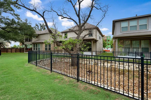 a view of a house with a fence and a tree