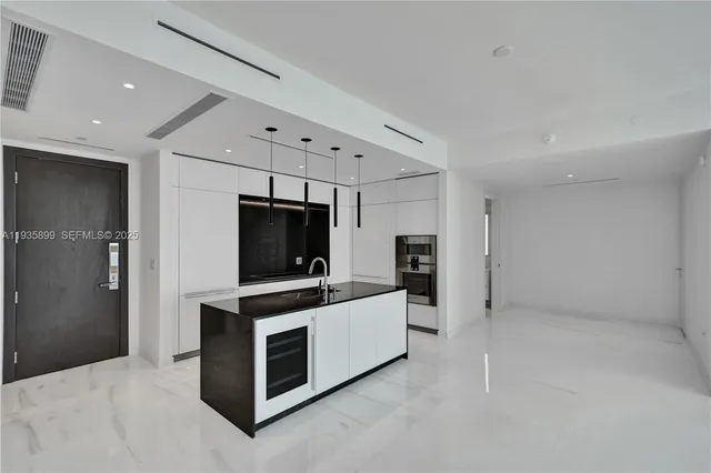 a kitchen with stainless steel appliances a sink and a refrigerator